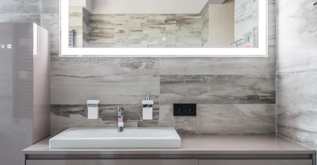 Sleek and clean bathroom design featuring an illuminated mirror and minimalist decor.