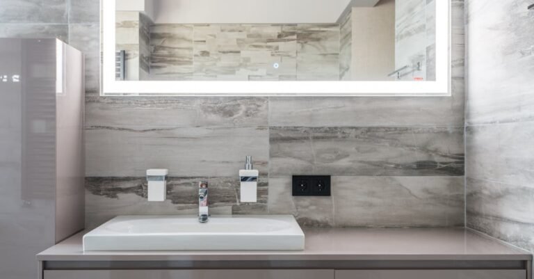 Sleek and clean bathroom design featuring an illuminated mirror and minimalist decor.